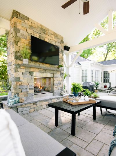 Stone patio fireplace with patio pavilion and paver patio