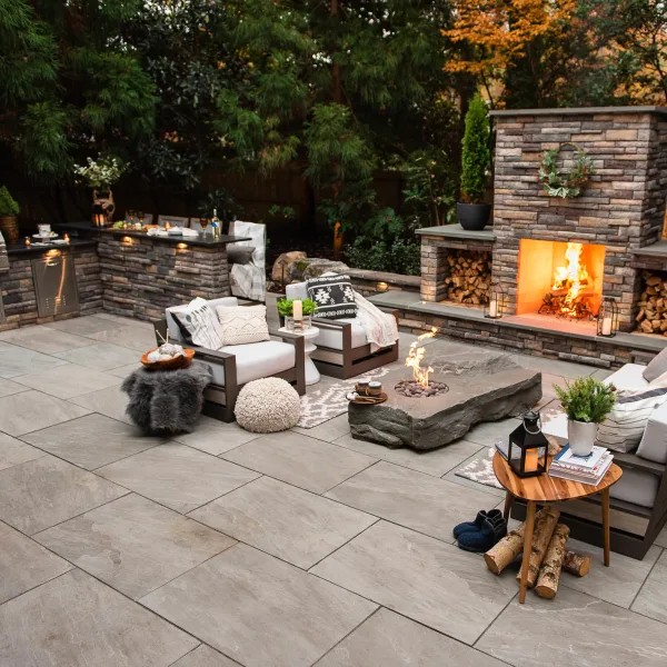 Cozy sitting area on a back patio with both a gas fire pit and fire place