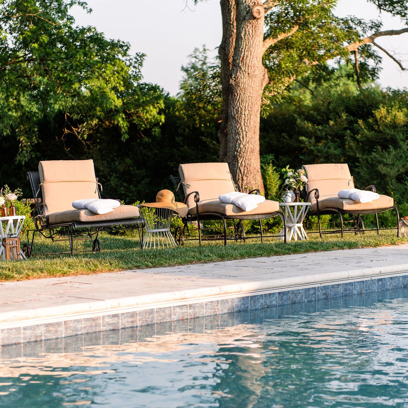 Chaise lounge chairs next to pool with travertine pool decking