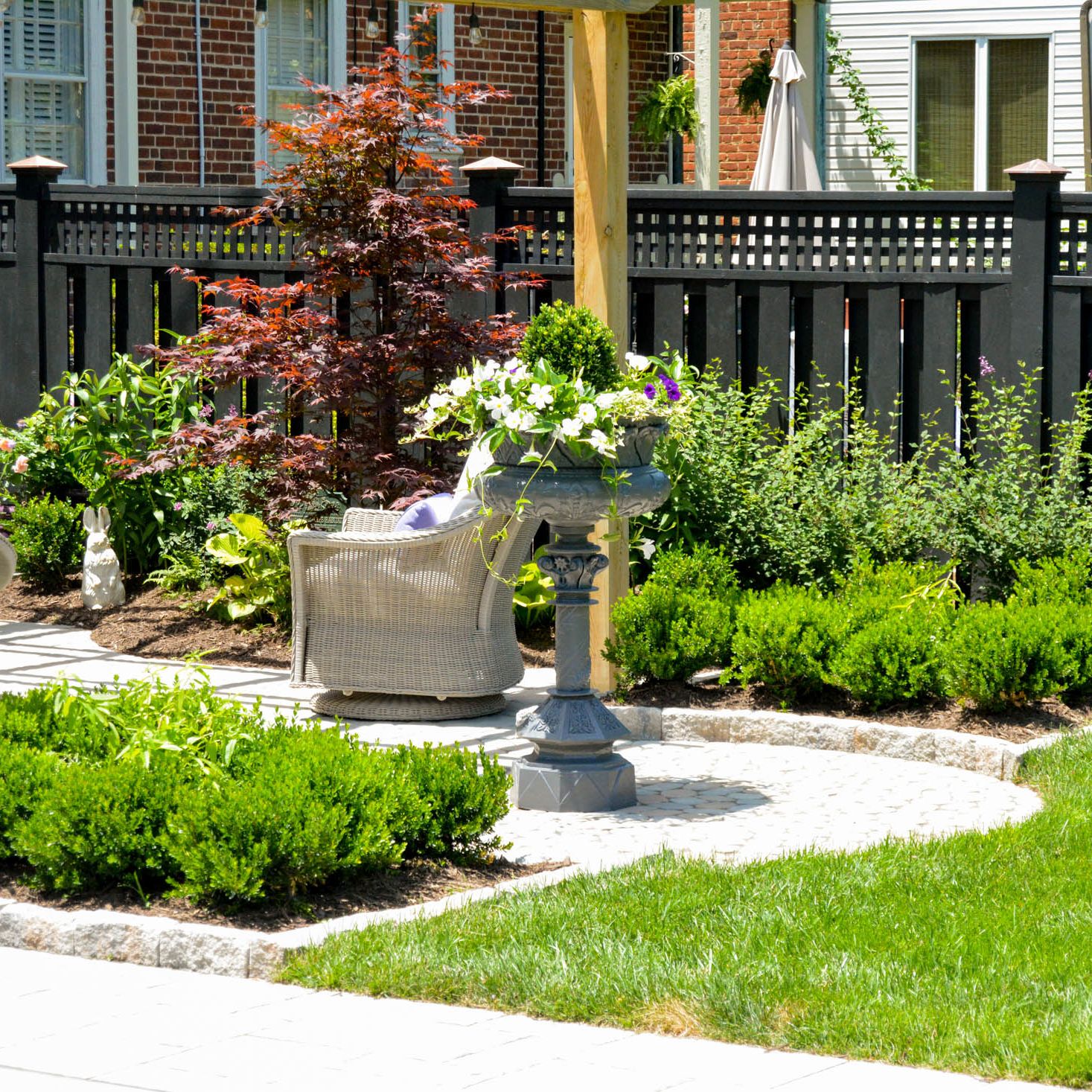 fenced in manicured lawn with a paver patio