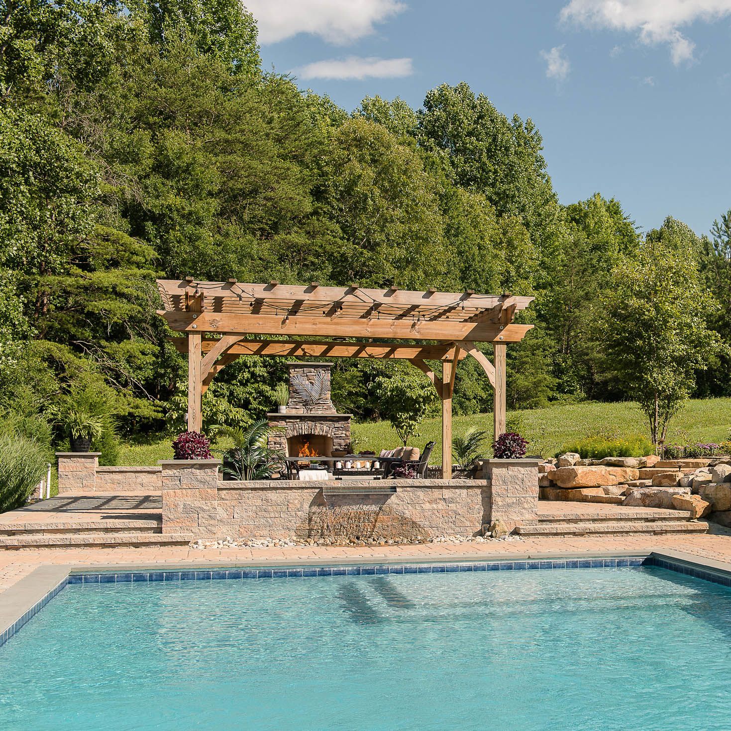 Gunite pool with paver pool decking, fireplace, and pergola