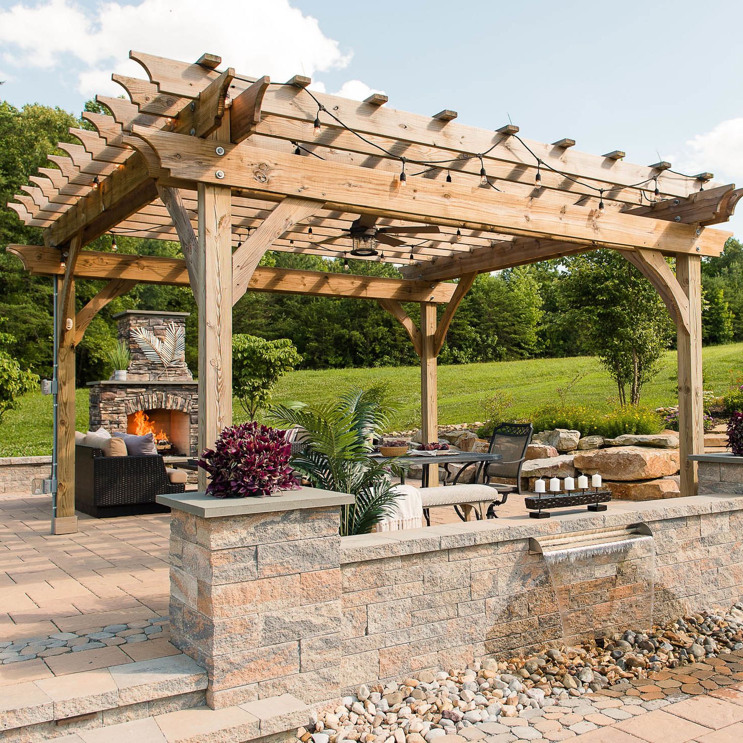 Paver patio with pergola, wall fountain, sitting walls, pillars, and outdoor fireplace