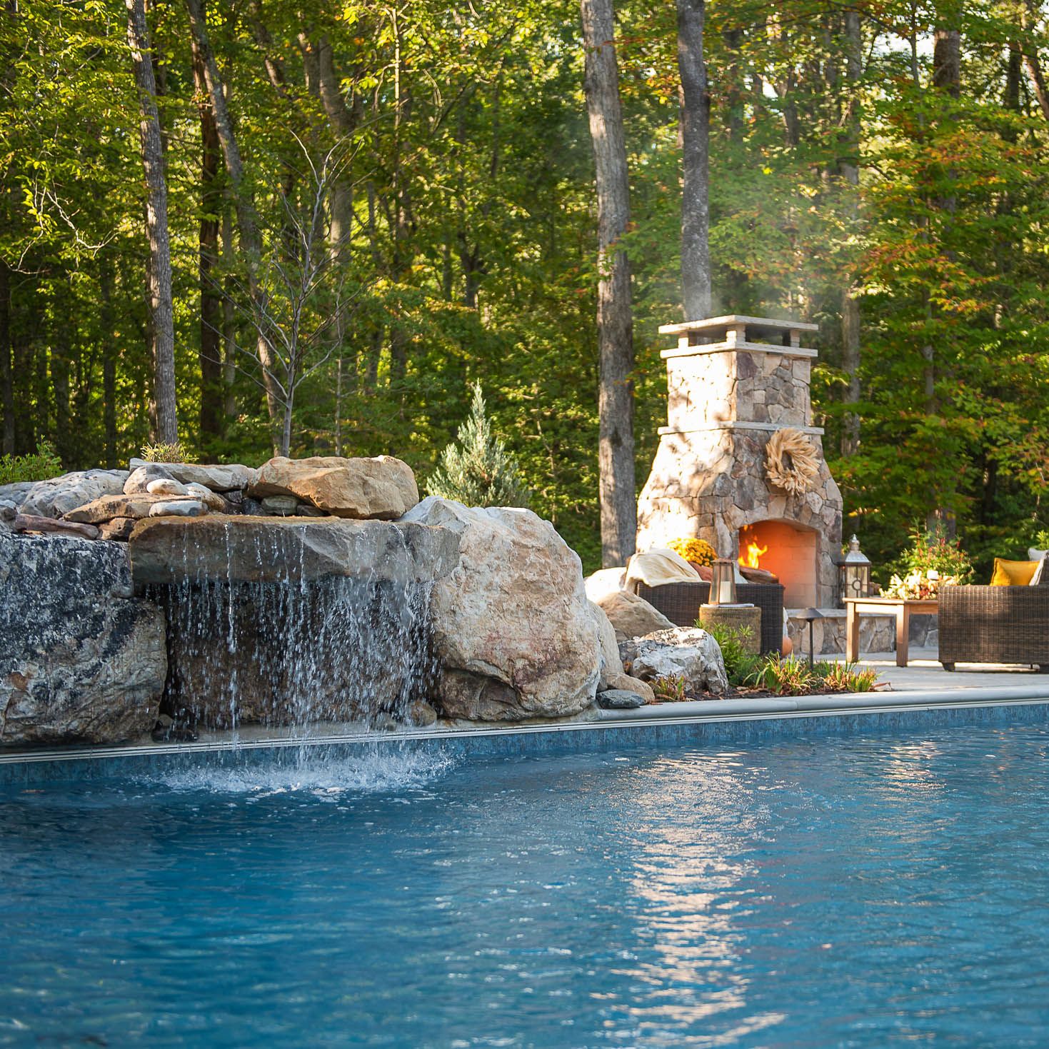 Stone waterfall atop the underground installed fiberglass pool