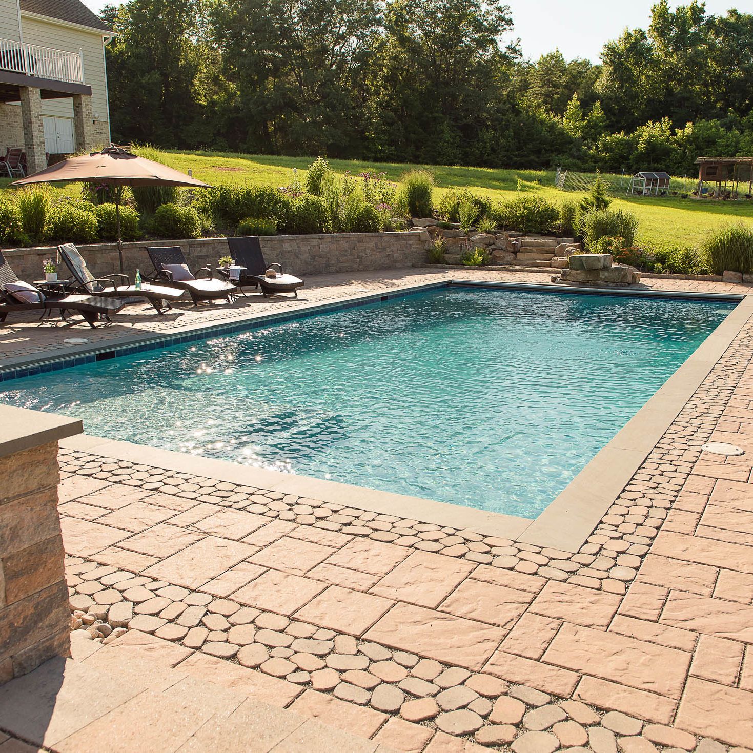 Gunite pool with paver decking and retaining wall